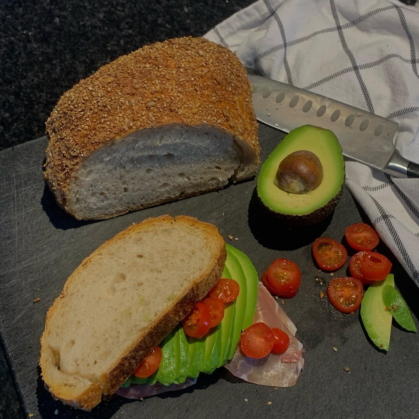 Bröd och avokado tillsammans med tomater 