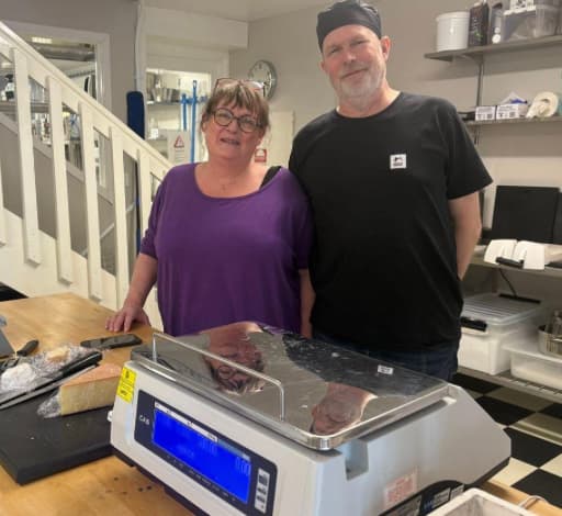 Håkan med fru på Kungsbacka ysteri bakom ostvågen