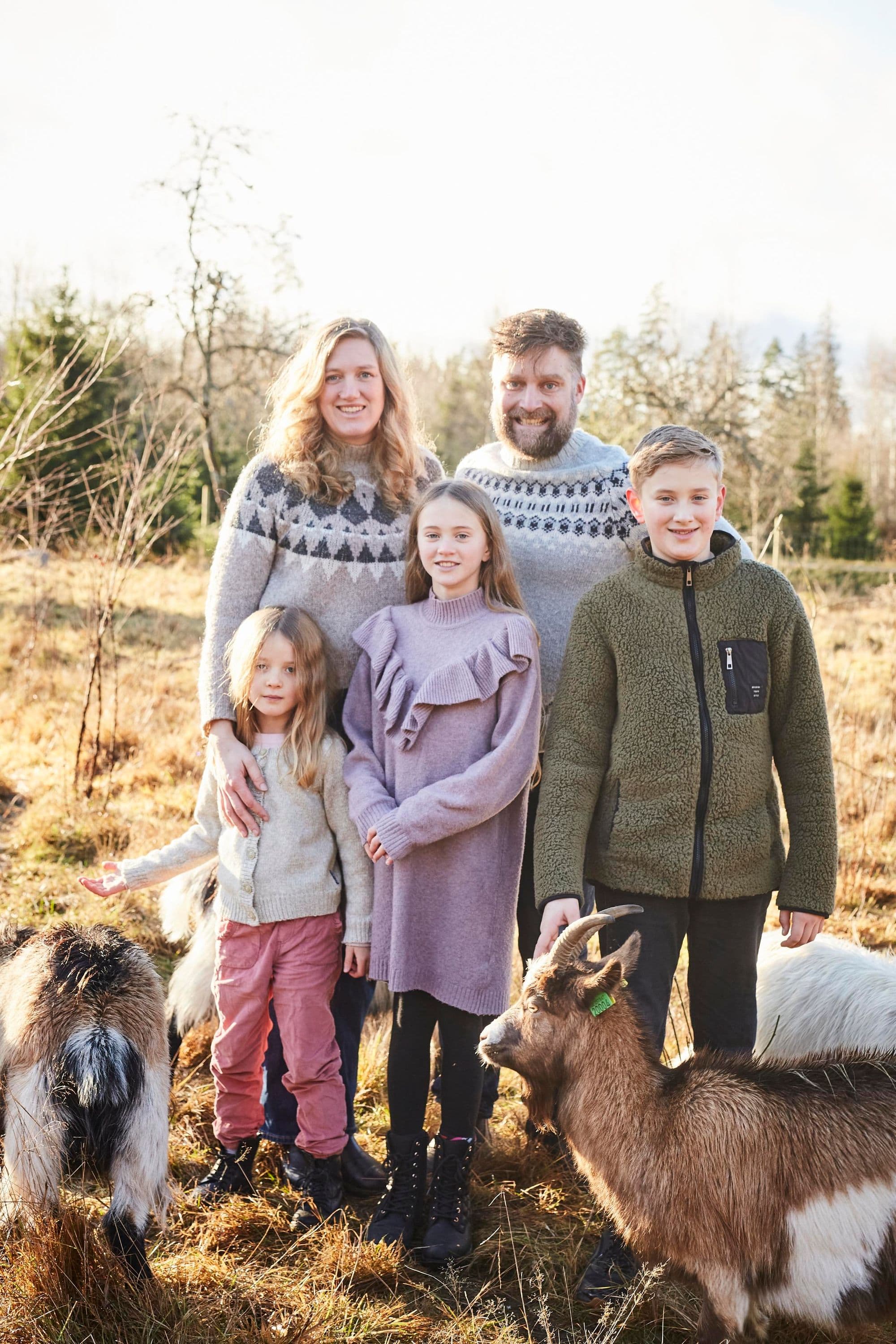 Familjen står på ett fält med getter