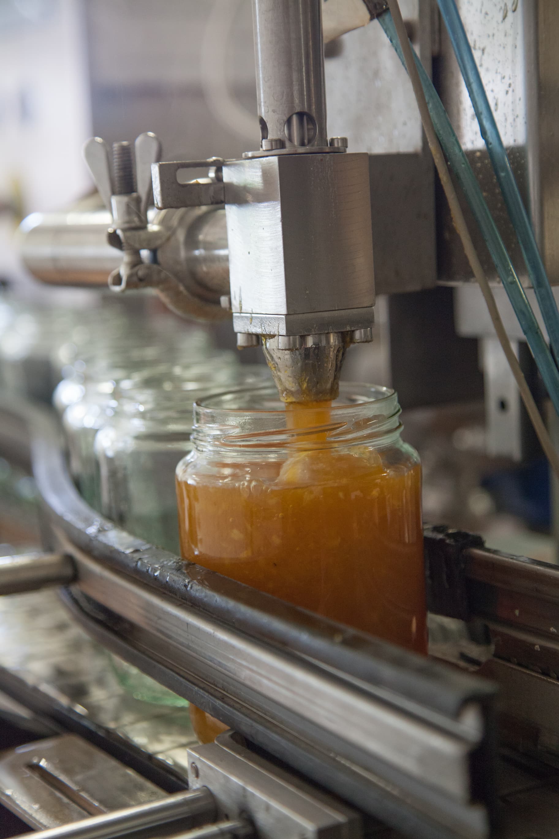 Marmelad på band som fylls i en glasburk